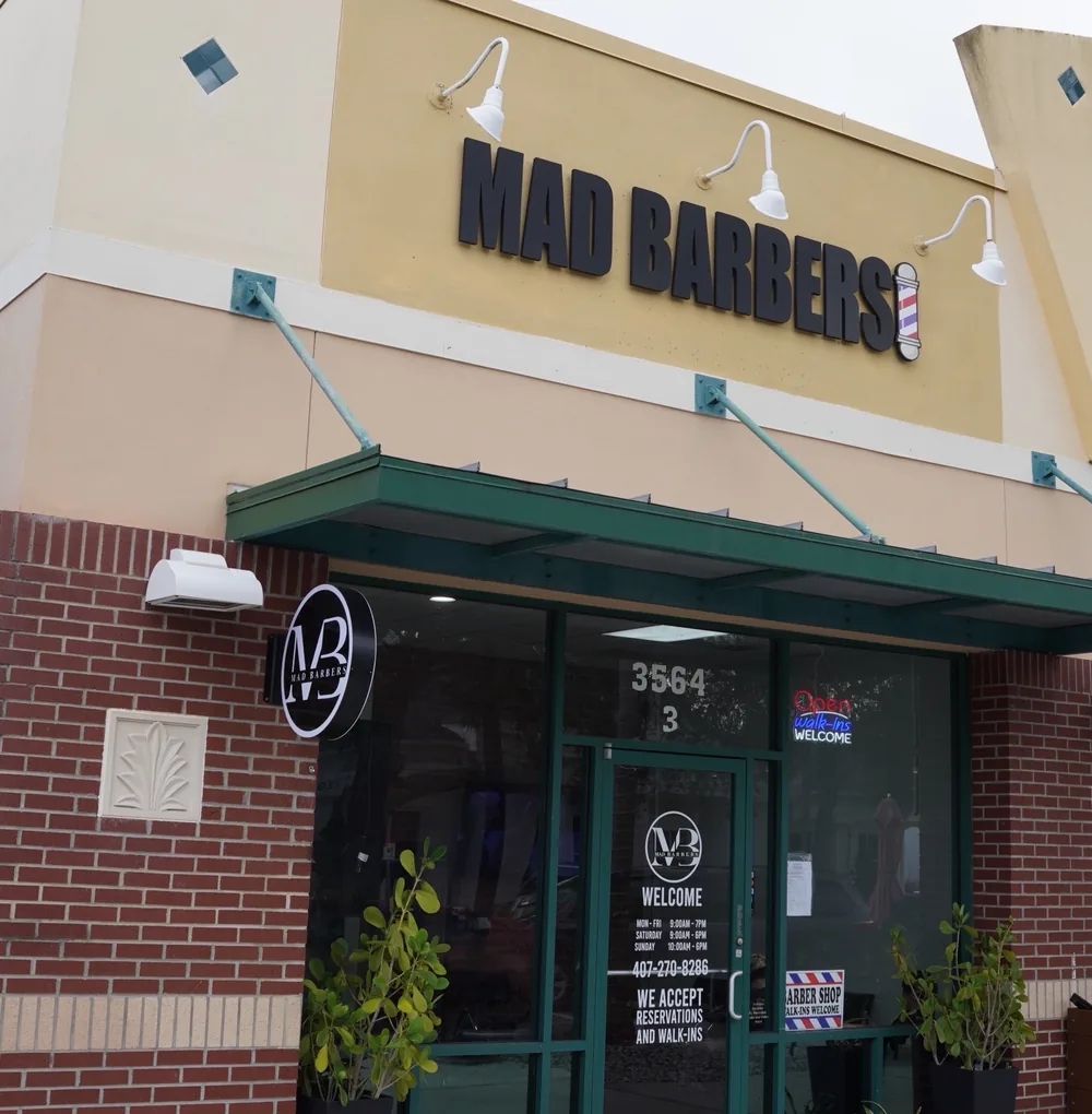 La fachada de Mad Barbers en Avalon Park, con el letrero de abierto en la vitrina